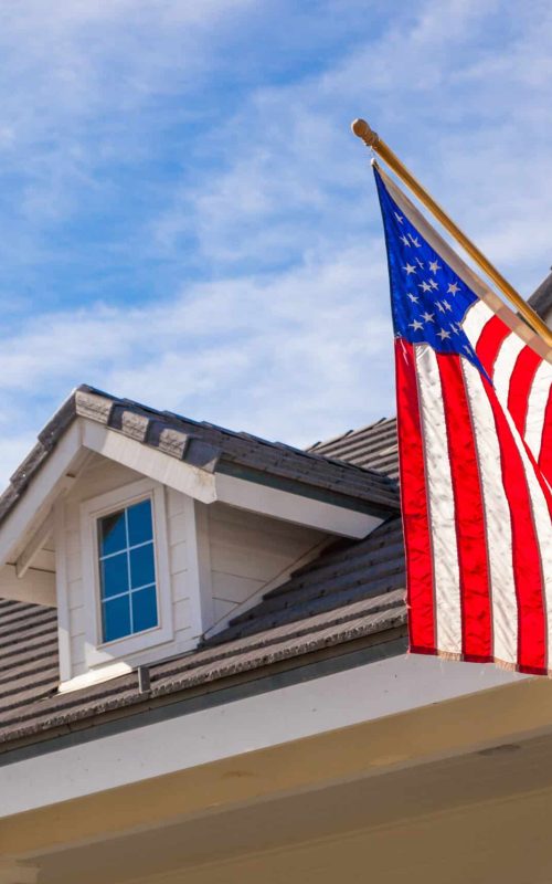 American,Flag,Hanging,From,House,Facade.